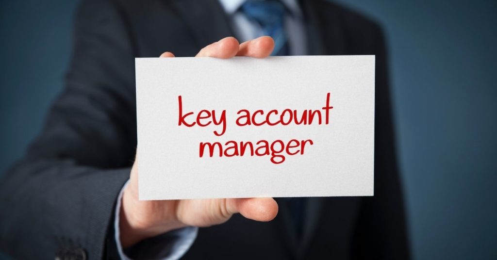 hand holding a sign saying "key account manager"